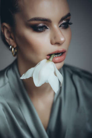 Beautiful woman holding a flower in her hand. High quality photoの写真素材
