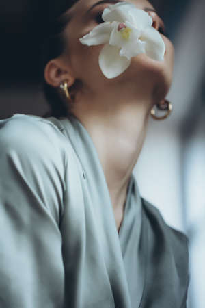 Beautiful woman holding a flower in her hand. High quality photoの写真素材