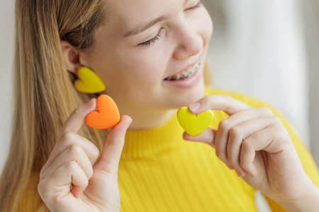 Teenage girl chooses jewelry earrings. Heart shaped earrings. St. Valentines Day. High quality photoの写真素材