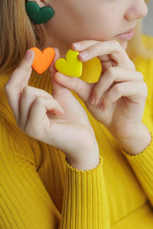 Teenage girl chooses jewelry earrings. Heart shaped earrings. St. Valentines Day. High quality photoの写真素材