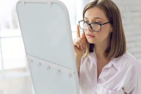 The woman chooses glasses for vision. High quality photoの写真素材