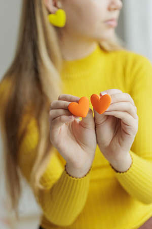 Teenage girl chooses jewelry earrings. Heart shaped earrings. St. Valentines Day. High quality photoの写真素材