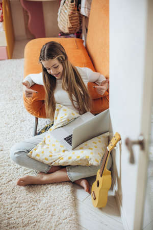 A teenage girl is learning to play the guitar, ukulele. High quality photoの写真素材