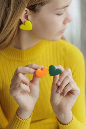 Teenage girl chooses jewelry earrings. Heart shaped earrings. St. Valentines Day. High quality photoの写真素材