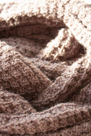 Knitting. Knitted scarf. Brown scarf. Hoby. Material background