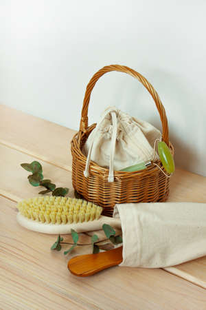 Home spa. Beauty and Medicine. Skin and body care. Massage brush with cactus bristles, facial massager, basket with textile bag on wooden backgroundの写真素材
