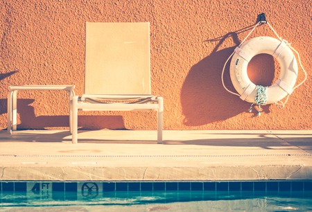 warm bench and lifeguard rescue tube by the poolsideの写真素材
