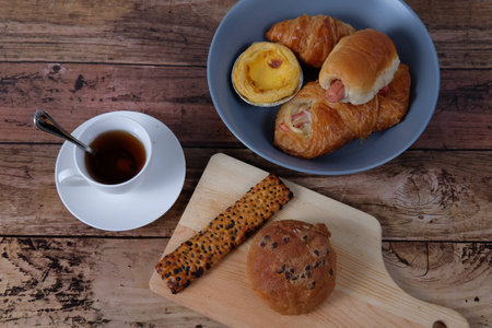 top views of coffee and bakeries on a cut board in wood backgroundの写真素材