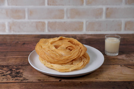Photography of indian food, ROTI on the table with condensed milk in old style background.の写真素材