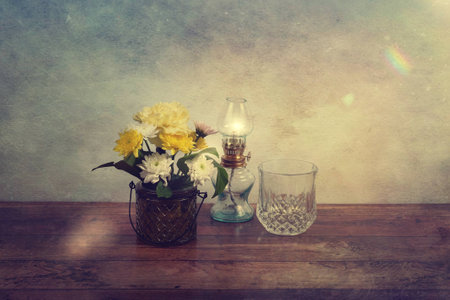scenery of flower vase and old lamp on the wooden table in vintage styleの写真素材