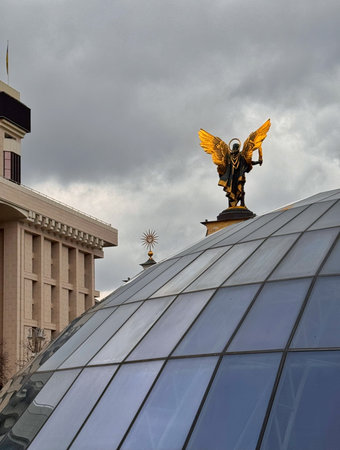 Glass dome of the Globus mall with the golden Archangel Michael statue above it on Maidan, Kyiv, Ukraine. Overcast daylight.の写真素材