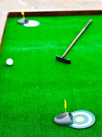 Mini golf field with ball and golf clubの写真素材