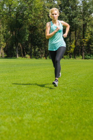 An active beautiful caucasian woman running outdoor in a parkの写真素材