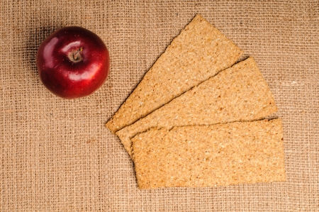 Red apple with crispbread on sacking backgroundの写真素材