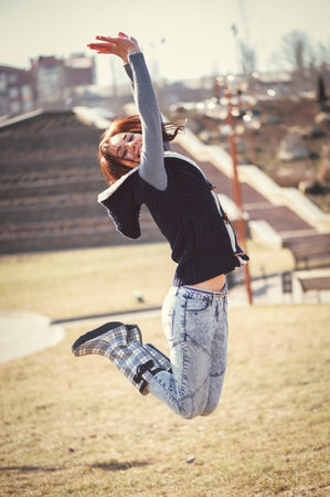 Young happy girl jumping in spring park
