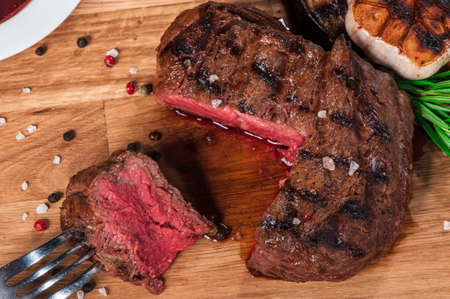 Steak with spices, thyme and chili served on a cutting boardの写真素材