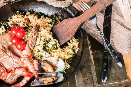 Fried rice with squid, prawns and shellfishes in old panの写真素材