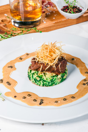Fried meat with whiskey sauce and potato puree with spinachの写真素材