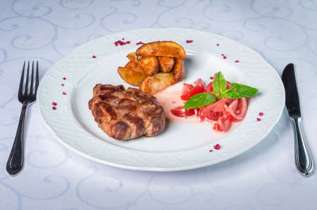 Grilled meat with tomato salad and fresh basilの写真素材