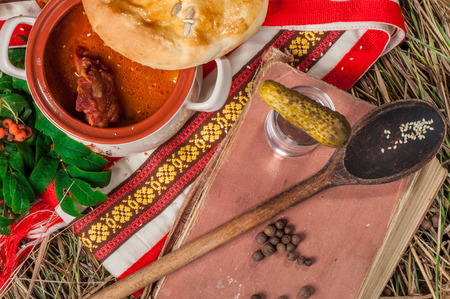 Hot soup with meat in a pot with bread coverの写真素材