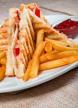 Grilled sandwiches with chicken and egg served with french friesの写真素材