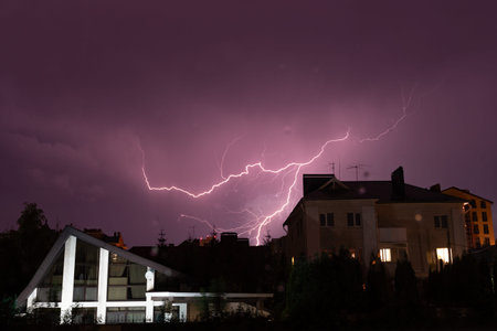 Thunderstorm with lightning in the night sky with clouds and clouds over the city. Lightning...