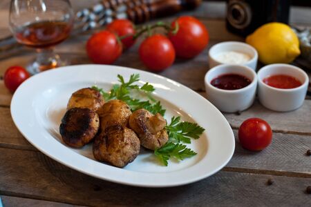 grilled mushrooms on a white plate. Wooden backgroundの写真素材