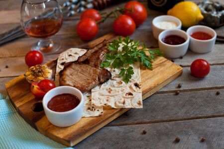 Steak on the bone. Steak on a wooden Board with vegetables and herbs. The view from the top.の写真素材