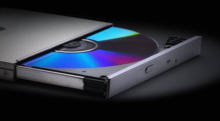 Ejecting or Inserting  cd, dvd or blueray disk into drive  without a computer on a black backgroundの写真素材