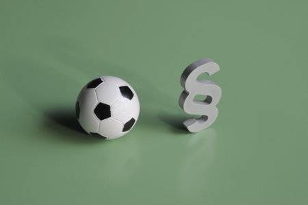 Close-up of a football and paragraph sign symbolize sports lawの写真素材