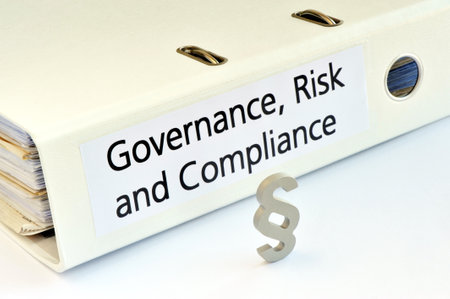 Close-up of a paragraph sign in front of an office folder titled Governance, Risk and Complianceの写真素材