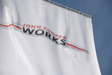 Munich, Bavaria, Germany - May 19, 2018: Flag with the logo of John Cooper Works in front of BMW headquarters in Munich, Germany - JCW is a British car marque owned by BMWのeditorial素材