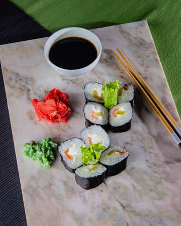Sushi. A serving of fresh Japanese rolls on a marble board with soy sauce, wasabi and pickled ginger.の写真素材