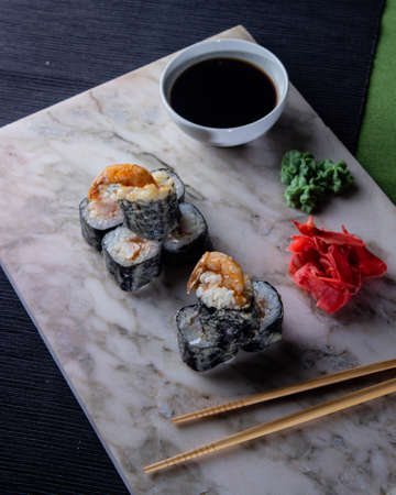 Sushi. A serving of fresh Japanese rolls on a marble board with soy sauce, wasabi and pickled ginger.の写真素材