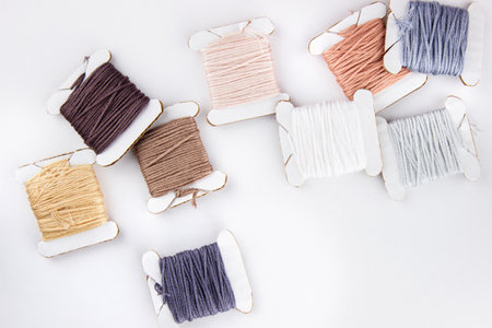 Skeins of cotton threads of different colors lie in a pile on a white backgroundの写真素材