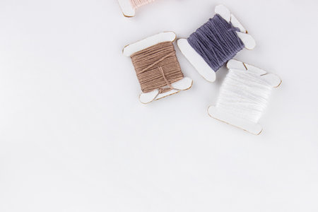 Skeins of cotton threads of different colors lie in a pile on a white backgroundの写真素材