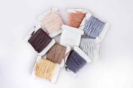 Skeins of cotton threads of different colors lie in a pile on a white backgroundの写真素材