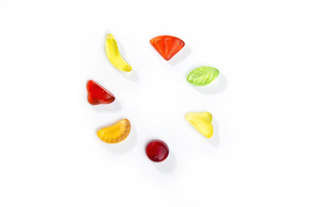 Gummy candies in the form of fruits and berries lies in a circle on a white background.の写真素材