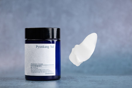 Glass blue jar of brand Pyunkang Yul face cream. There is a smudge in the air nearby, a sample(swatch) of the productのeditorial素材