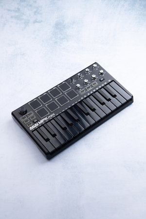 AKAI mpk mini mk2 black on a blue and white background. Side viewのeditorial素材