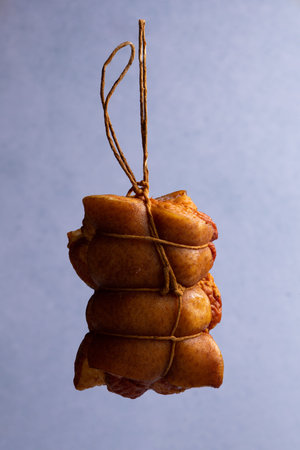 smoked spicy pork roll levitates on blue background