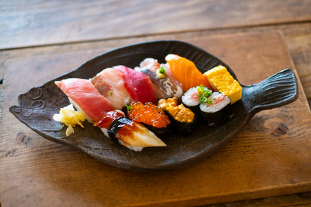 Sushi set in black plate on wooden table, Japanese food styleの写真素材