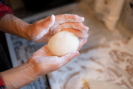 Hands of an old woman kneading a dough in the kitchenの写真素材