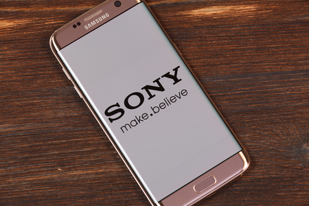 Kazan, Russian Federation - Aug 5, 2018: Man holding smartphone with Sony logo with the finger on the screenのeditorial素材