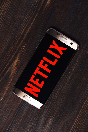 Kazan, Russian Federation - Aug 5, 2018: Netflix logo on a TV screen. Netflix app on Laptop screen. Netflix is an international leading subscription service for watching TV episodes and movies.のeditorial素材