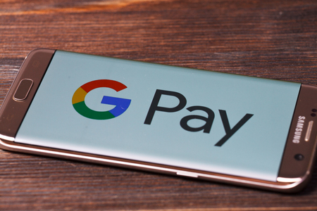 Kazan, Russian Federation - Aug 5, 2018: hand holding a brand new Samsung Galaxy S7 mobile phone which displays the Android Pay app on the touch screenのeditorial素材