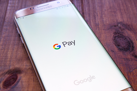 Kazan, Russian Federation - Sep 15, 2017: hand holding a brand new Samsung Galaxy S7 mobile phone which displays the Android Pay app on the touch screenのeditorial素材