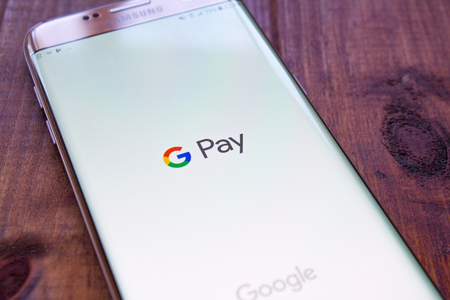 Kazan, Russian Federation - Sep 15, 2017: hand holding a brand new Samsung Galaxy S7 mobile phone which displays the Android Pay app on the touch screenのeditorial素材