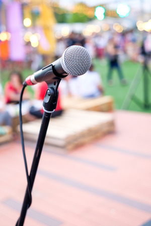 Close up of microphone in concert or conference room with blur people in the backgroundの写真素材