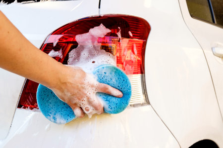 close up of hand washing a car with sponge and soapの写真素材